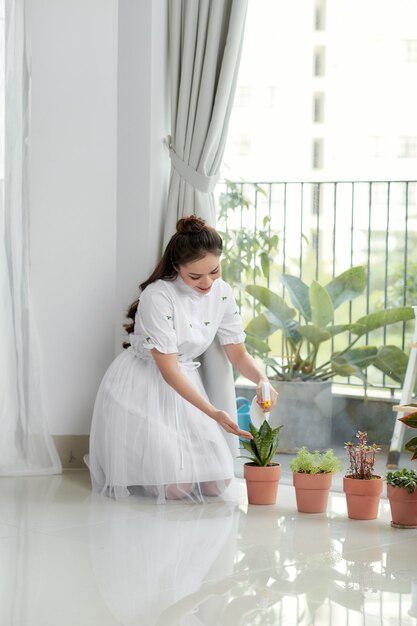 Femme s'occupant d'une plante d'intérieur.