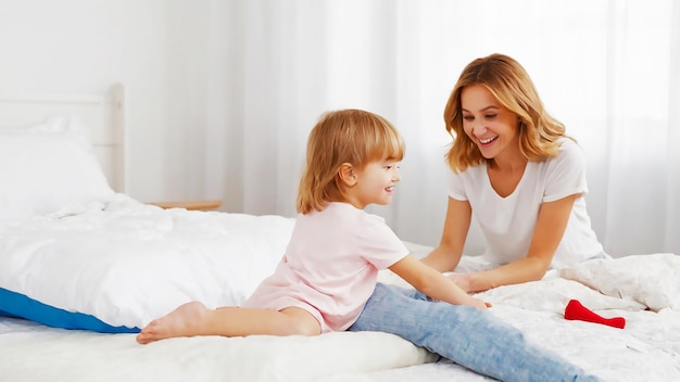 une femme et sa fille sont assises sur un lit. L'une d'elles tient un petit enfant.