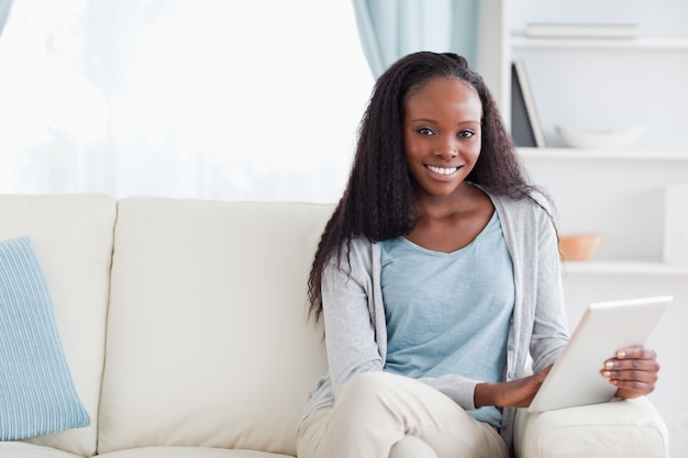 Femme avec sa tablette sur le canapé