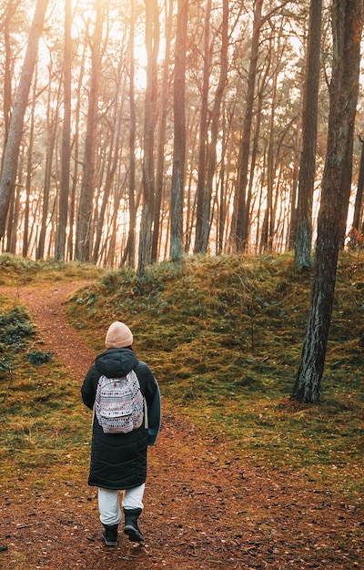 Femme avec un sac à dos marchant dans le parc Concept de voyager seul et à l'extérieur en découvrant Personne dans la forêt