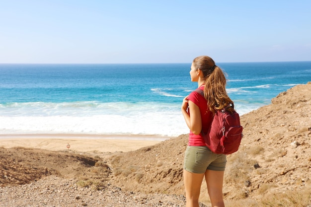 Femme avec un sac à dos profitant de la vue