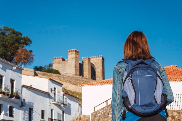Femme avec sac à dos en regardant un château