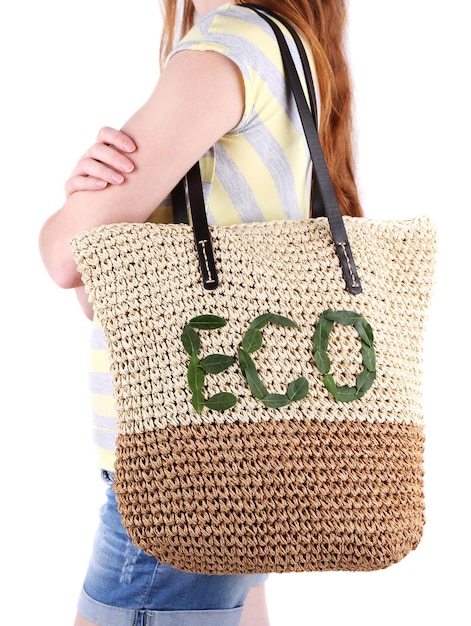 Femme avec sac Eco en osier d'été sur fond de mur gris