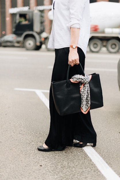 Une femme avec un sac sur le fond de la ville