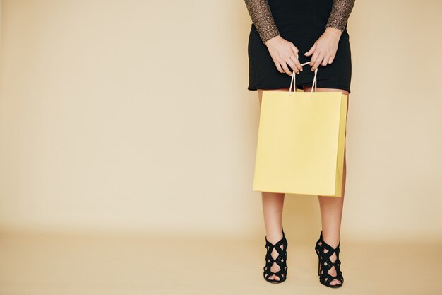 Femme avec sac shopping jaune pastel