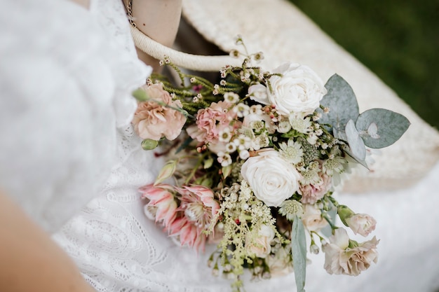 Femme avec un sac tissé plein de fleurs