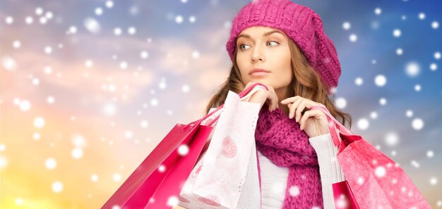 Photo femme avec des sacs d'achat sur fond de neige