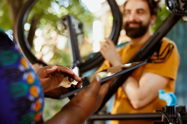 Photo une femme saisit une tablette pour réparer un vélo.