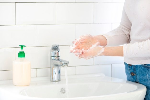 Femme, salle bains, lavage, mains