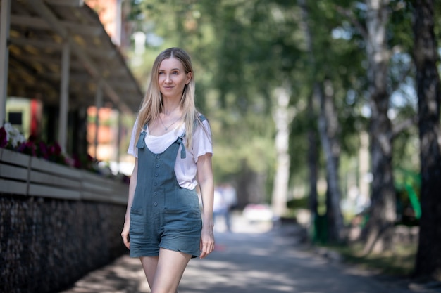 Femme en salopette marche en été dans la rue