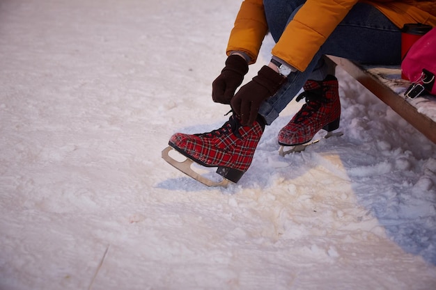 La femme sans visage met des patins sur son pied