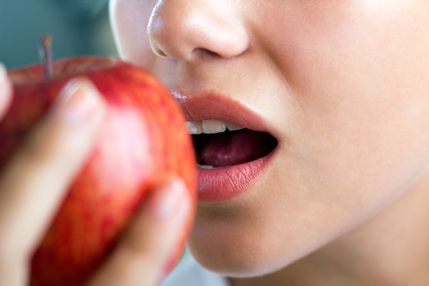 femme sans visage se préparant à mordre la pomme