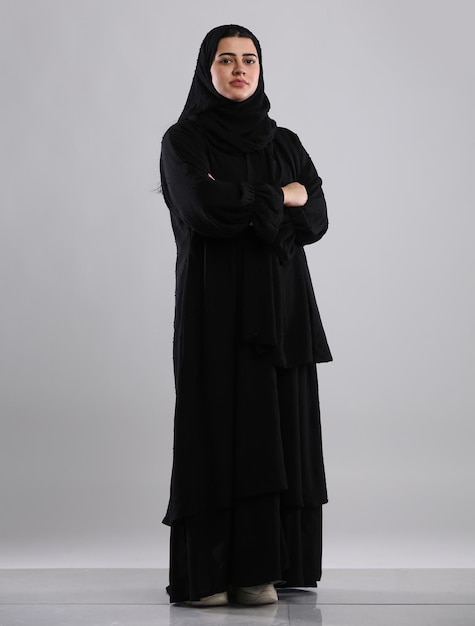 Femme saoudienne portant une abaya debout les mains jointes