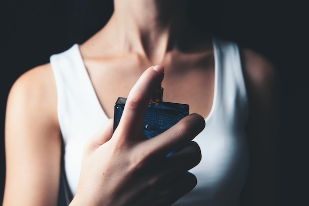 La femme saupoudre le parfum sur son cou