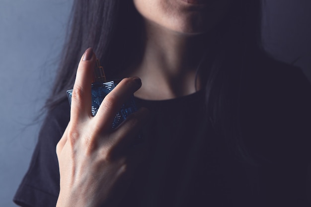 La femme saupoudre le parfum sur son cou