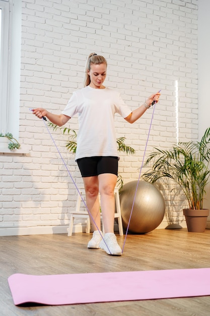 Une femme sautant la corde dans un salon lumineux rempli de plantes