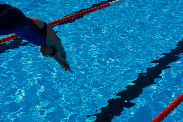 Photo une femme sautant dans la piscine.