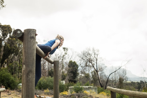 Femme sautant par-dessus les obstacles pendant la course d'obstacles