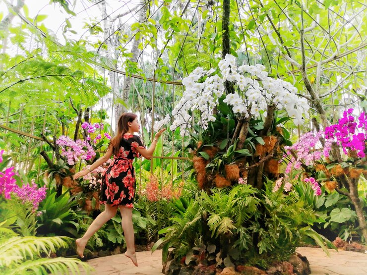 Photo une femme sautant près des plantes en fleurs.