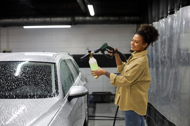 Femme savonnant une voiture