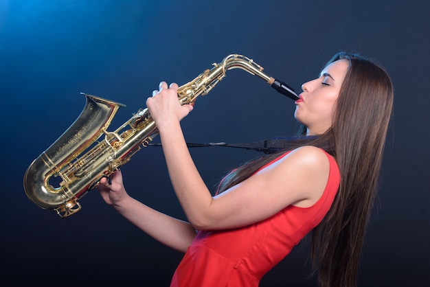 Femme saxophoniste en robe rouge