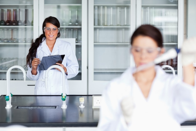 Photo femme scientifique écrivant sur un presse-papiers