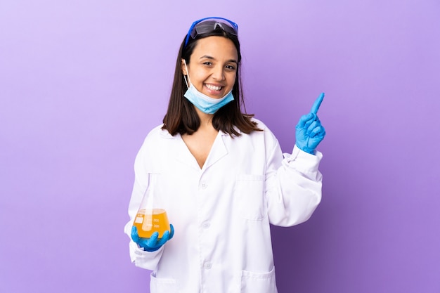 Femme scientifique enquêtant sur un vaccin pour guérir la maladie heureuse et pointant vers le haut