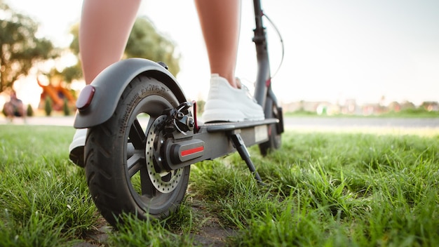 Femme avec scooter électrique sur la rue de la ville