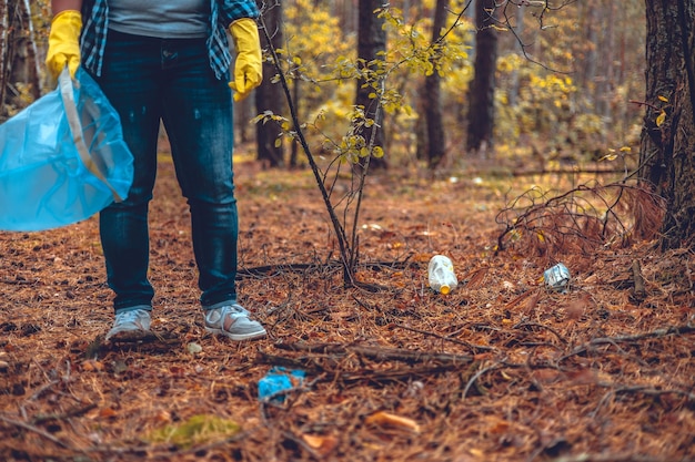 Photo une femme se bat pour sauver la forêt des ordures une femme avec un sac à ordures dans les mains collecte