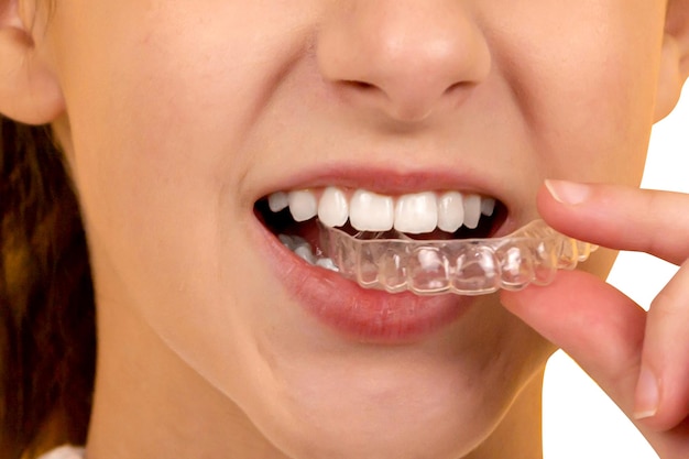 Une femme se brosse les dents avec une brosse à dents en mousse.