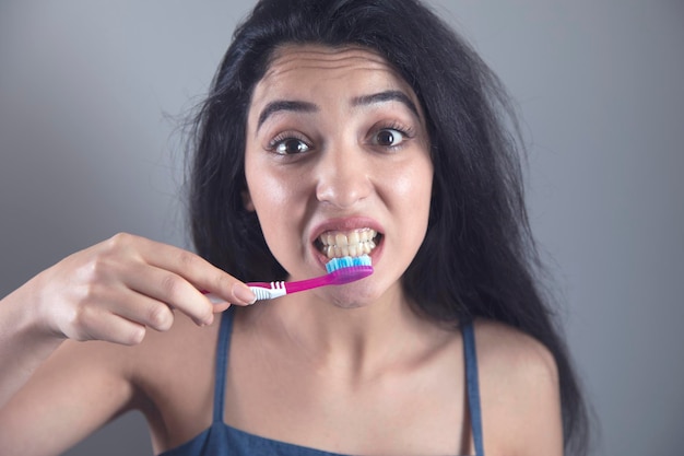 Femme se brosser les dents avec une brosse à dents