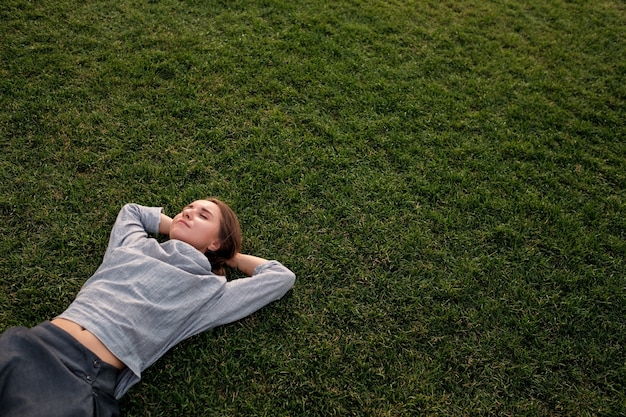 Femme se couche sur l'herbe et se repose