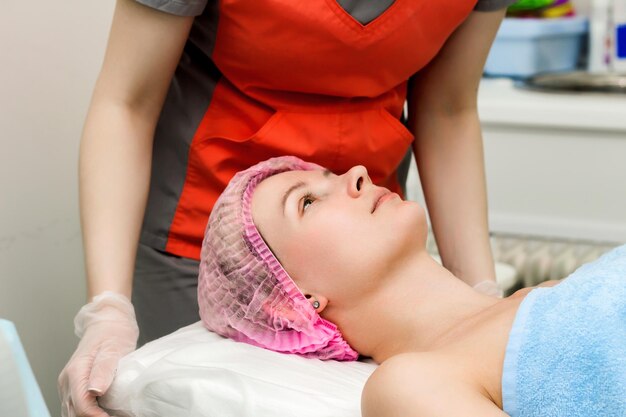 Une femme se couche et se prépare à subir une intervention cosmétique ou clinique