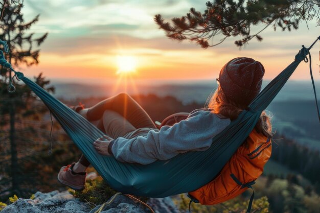 Photo une femme se détendant dans un hamac au coucher du soleil parfait pour les voyages et les loisirs