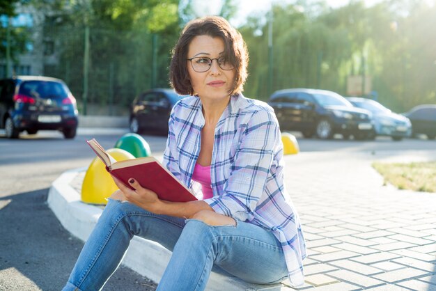 Femme se détendant dans la ville en lisant un livre