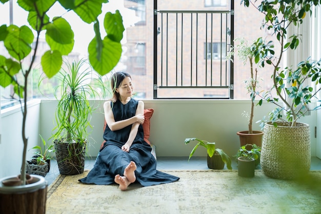 Une femme se détendant entourée de plantes à feuillage