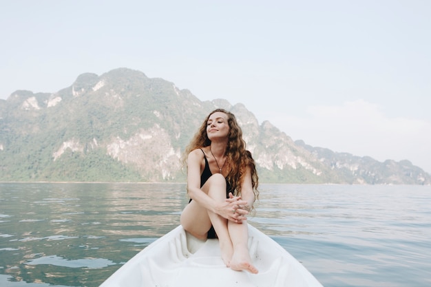 Femme se détendre sur un canot au bord d&#39;un lac