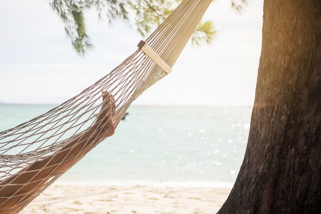 Femme se détendre dans le hamac à la plage.