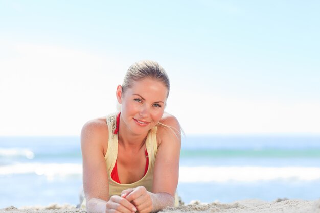 Une femme se faire bronzer à la plage