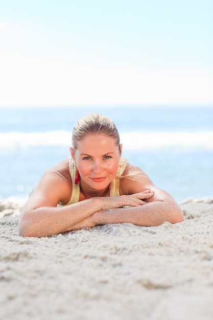 Une femme se faire bronzer sur la plage