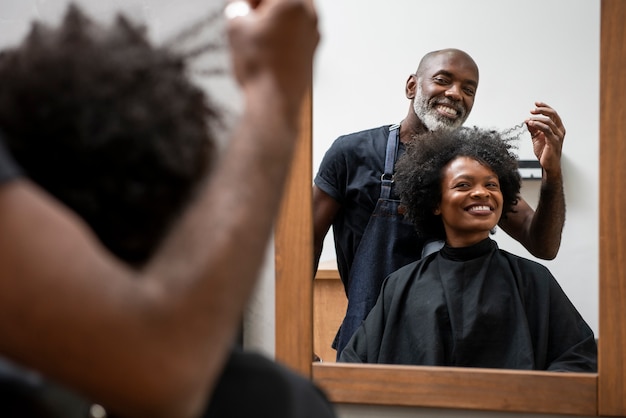 Femme se fait coiffer au salon par un coiffeur