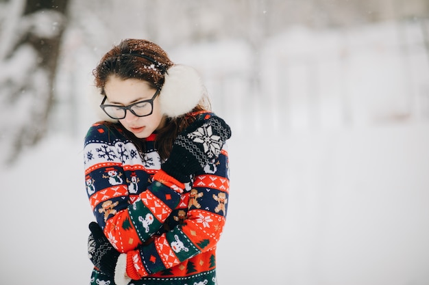 La femme se figea et soupira de ses mains pour les réchauffer. Fille sur le paysage d'hiver dans la ville. La femme gelée se tient près du parc dans le froid de l'hiver