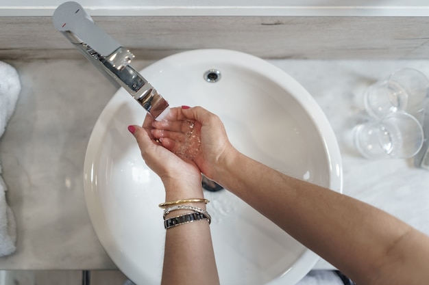 Femme se lavant les mains dans un bassin rond, prise de vue aérienne d'en haut