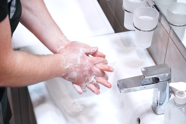 Photo une femme se lave les mains dans la salle de bain.