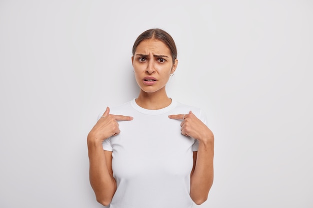 une femme se montre elle-même et demande pourquoi j'ai été surprise par des mots offensants vêtus de poses de t-shirt décontractées sur blanc indique soi