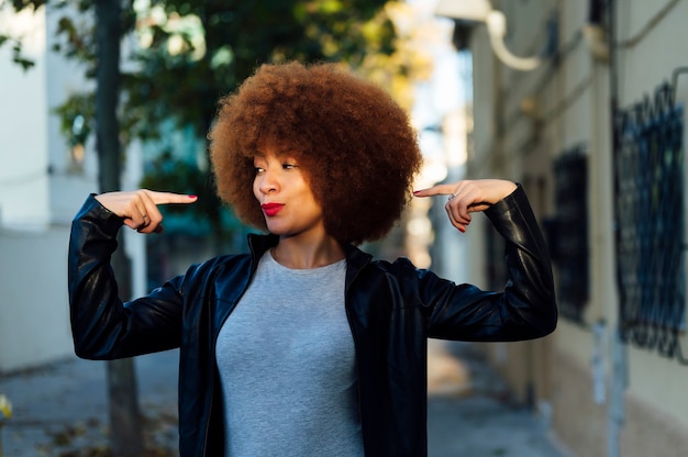 Photo femme se pointant du doigt dans la rue