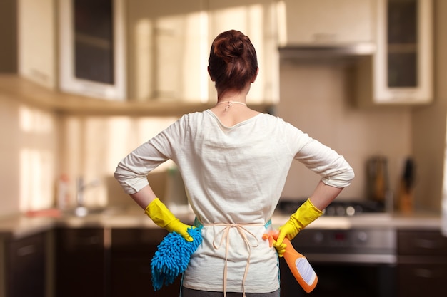 Femme se préparant à nettoyer la cuisine. Debout en arrière