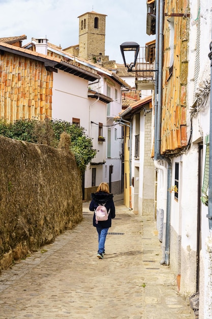 Femme se promenant dans les rues étroites du joli village médiéval de Hervas Caceres