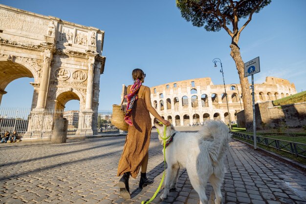 Une femme se promène avec un chien près du colisée à rome