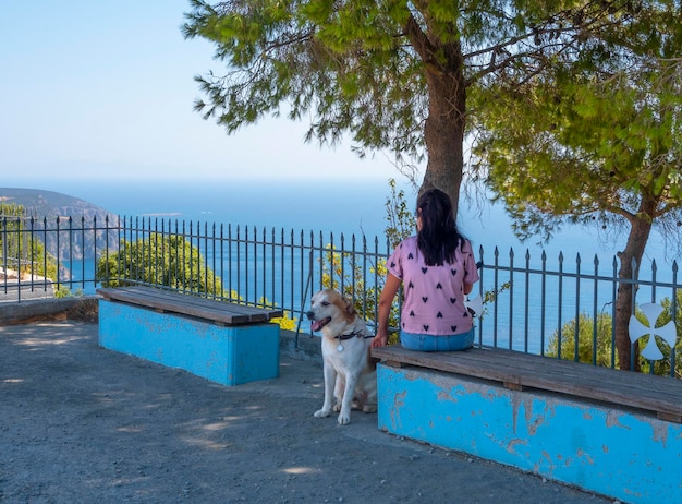 Une femme se promène avec son chien sur la digue de la mer Égée en Grèce